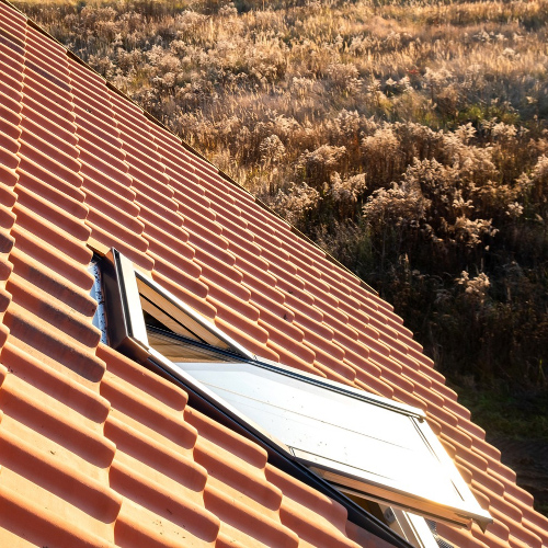 Couvreur au travail sur une toiture à Gan